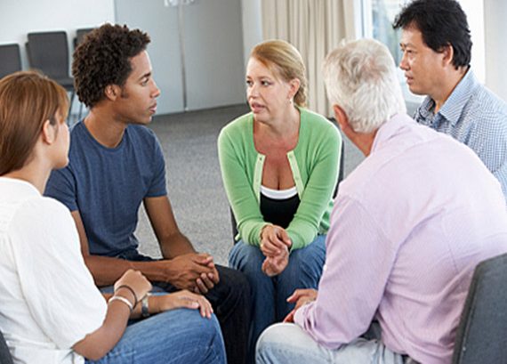 A group of people sitting in a circle talking.