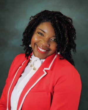 A woman in red jacket smiling for the camera.